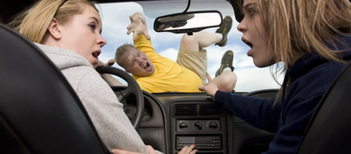 A teenage girl driving and playing with the radio while her friend is showing that she just hit someone because she was distrated by the radio.